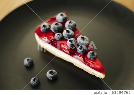 Strawberry cheesecake with blueberries on black Strawberry cheesecake with blueberries on black 63394763