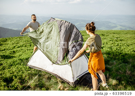 Couple setting up the tent in the mountains Couple setting up the tent in the mountains 63396519
