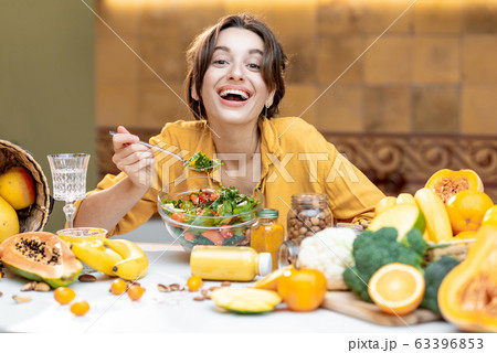 Young woman with healthy fresh food on the kitchen Young woman with healthy fresh food on the kitchen 63396853