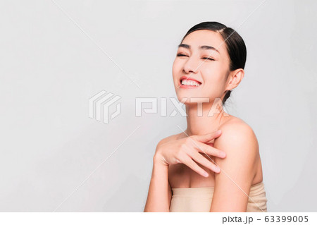young beautiful asian woman with clean and bright skin, Cosmetic Beauty Concept,hands touch on the cheek, smiling and friendly face isolated on grey background young beautiful asian woman with clean and bright skin, Cosmetic Beauty Concept,hands touch on the cheek, smiling and friendly face isolated on grey background 63399005