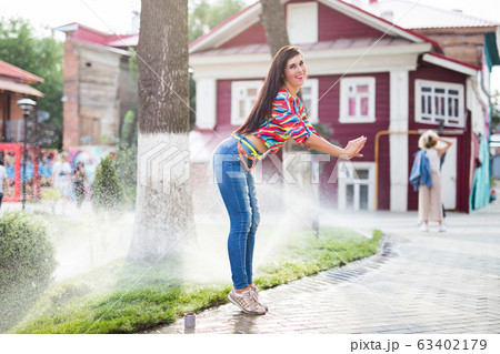 Beautiful attractive young woman having fun and enjoying and dancing in the park on a sunny summer day. 63402179