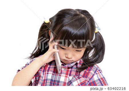 真剣な顔でスマートフォンで話をする幼い女の子。スマートフォン、相談、悩み、電話イメージ 63402216