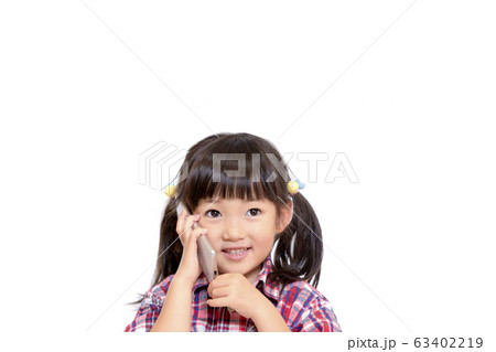 笑顔でスマートフォンで通話をする幼い女の子。スマートフォン,通話,笑顔,幸せイメージ 笑顔でスマートフォンで通話をする幼い女の子。スマートフォン,通話,笑顔,幸せイメージ 63402219