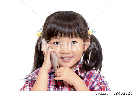 笑顔でスマートフォンで通話をする幼い女の子。スマートフォン,通話,笑顔,幸せイメージ 笑顔でスマートフォンで通話をする幼い女の子。スマートフォン,通話,笑顔,幸せイメージ 63402220