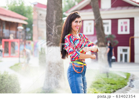Beautiful attractive young woman having fun and enjoying and dancing in the park on a sunny summer day. 63402354