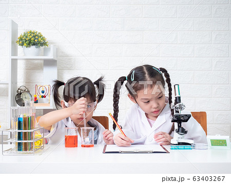 Two little asian sibling girl role playing a scientist in science lab with equipment. Learning and education of kid. Two little asian sibling girl role playing a scientist in science lab with equipment. Learning and education of kid. 63403267