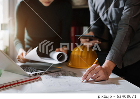 Businessman working as a team discussing data working and tablet, laptop with on on architectural project at construction site at desk in office. 63408671