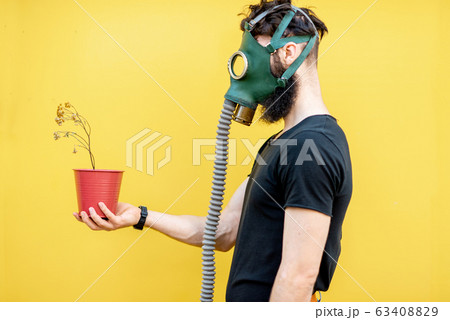 Man with gas mask and flowerpot 63408829