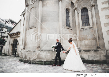 Gorgeous wedding couple walking in the old city 63409209
