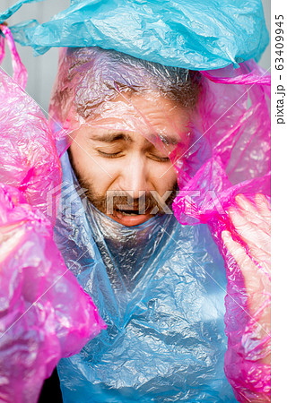 Conceptual portrait of a man covered with plastic bags Conceptual portrait of a man covered with plastic bags 63409945