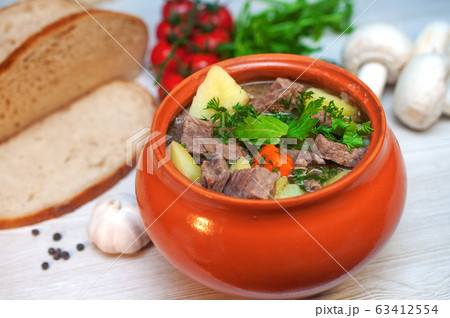Roast in a pot with beef meat and potatoes on the table Roast in a pot with beef meat and potatoes on the table 63412554
