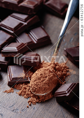Broken  chocolate pieces and cocoa powder . 63412756
