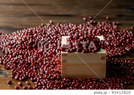 Red adzuki beans in square wooden measuring cup. 63412820