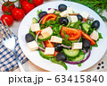 Greek salad with tomatoes, cucumbers and feta cheese with olives on the table 63415840