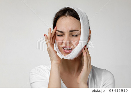 young sad woman suffering from tooth pain 63415919