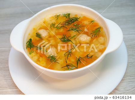 Chicken soup with meatballs and pasta on the table 63416134