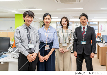 オフィスで立つ新入社員とそれを見守る上司 オフィスで立つ新入社員とそれを見守る上司 63416328