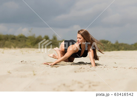 Gorgeous young female crawling on beach 63416542