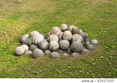 A pile of old cannonballs on the green grass A pile of old cannonballs on the green grass 63417435