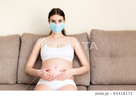 Pregnant woman in protective medical mask Pregnant woman in protective medical mask 63418175