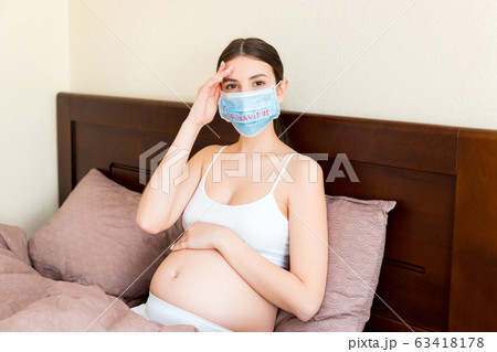 Pregnant woman in protective medical mask Pregnant woman in protective medical mask 63418178