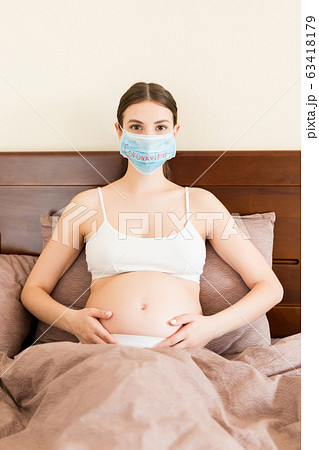 Pregnant woman in protective medical mask 63418179