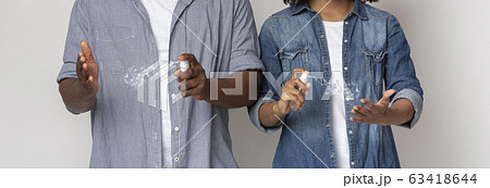 Virus Spread Prevention. Unrecognizable couple applying antibacterial disinfectant spray on hands Virus Spread Prevention. Unrecognizable couple applying antibacterial disinfectant spray on hands 63418644