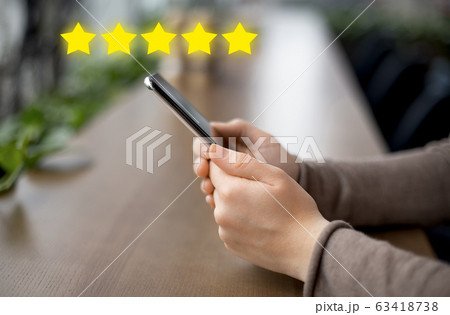 Woman blogger holding cellphone with customer review Woman blogger holding cellphone with customer review 63418738