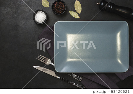 Empty black slate plate on dark stone table and Empty black slate plate on dark stone table and 63420621