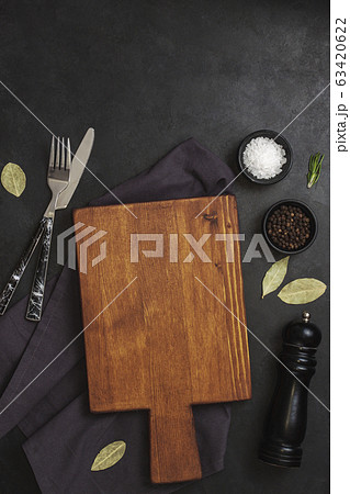 Cutting Board, rosemary and spices on dark table. Cutting Board, rosemary and spices on dark table. 63420622