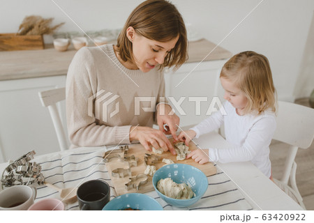 A young mother spends time with her little daughter at home. A young mother spends time with her little daughter at home. 63420922