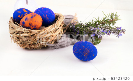 A nest with easter eggs and rosemary close up on a white background 63423420