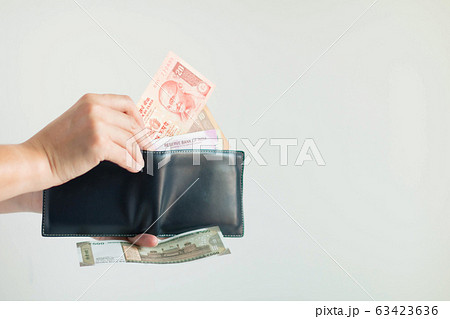Hands picking Rupees money from the short wallet for payment in the Republic of India. Hands picking Rupees money from the short wallet for payment in the Republic of India. 63423636
