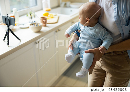 Happy pretty woman playing with her baby in the kitchen Happy pretty woman playing with her baby in the kitchen 63426098