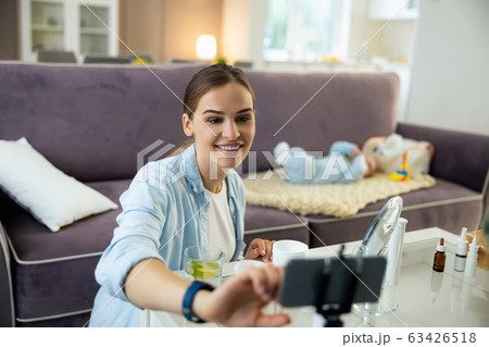 Happy attractive lady making video for her vlog in room Happy attractive lady making video for her vlog in room 63426518