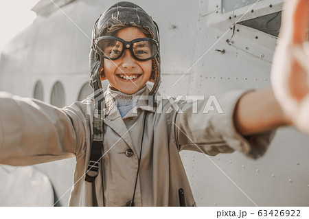 Happy cute boy in aviator hat making photo outdoors 63426922
