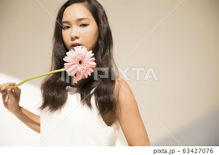 花を手に持つ女性のポートレートの写真素材