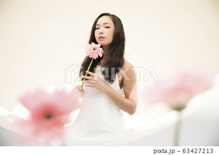 花を手に持つ女性のポートレートの写真素材