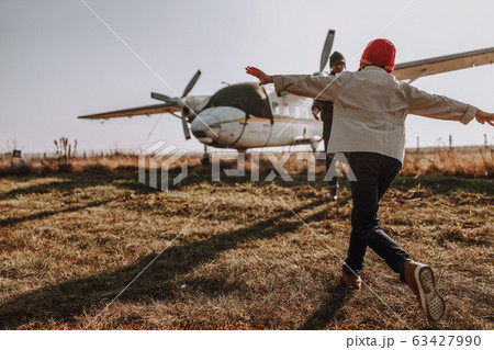 Little kid having fun with his father near plane 63427990