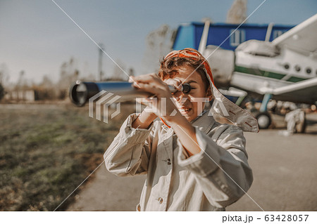 Happy kid looking through telescope near an airplane 63428057
