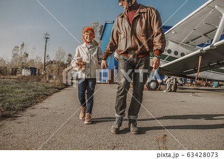 Happy little boy with toy walking with dad 63428073