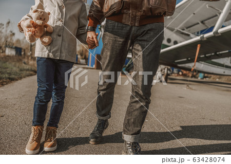 Father and son walking together near plane 63428074