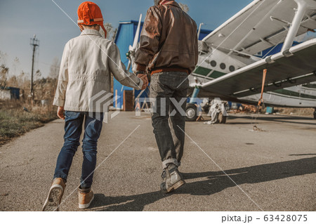 Young father and his son holding hands outdoors 63428075