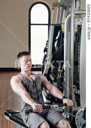 Bodybuilder concentrated on doing exercise 63430669