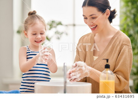 girl and her mother are washing hands girl and her mother are washing hands 63431695