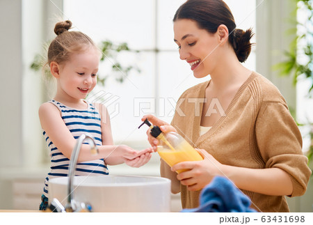 girl and her mother are washing hands girl and her mother are washing hands 63431698
