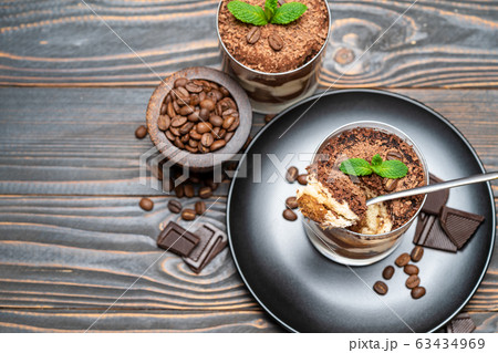 Classic tiramisu dessert in a glass cup on wooden background Classic tiramisu dessert in a glass cup on wooden background 63434969