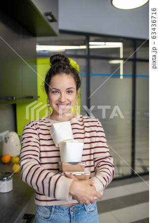 Young woman holding asian food boxes in the kitchen Young woman holding asian food boxes in the kitchen 63436716