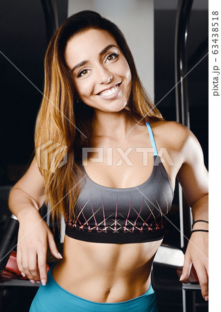 Fitness woman pumping up muscles workout in gym 63438518