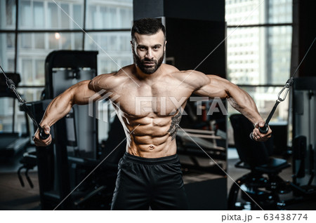 Muscular bodybuilder at cable crossovers fitness Muscular bodybuilder at cable crossovers fitness 63438774